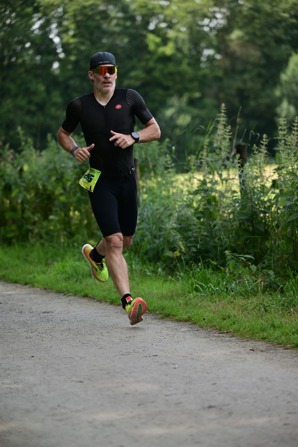 Läufer im Trisuit auf einem Waldweg